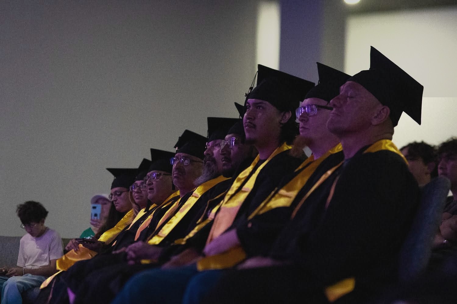 Graduates in caps and gowns seated during the UHC graduation ceremony